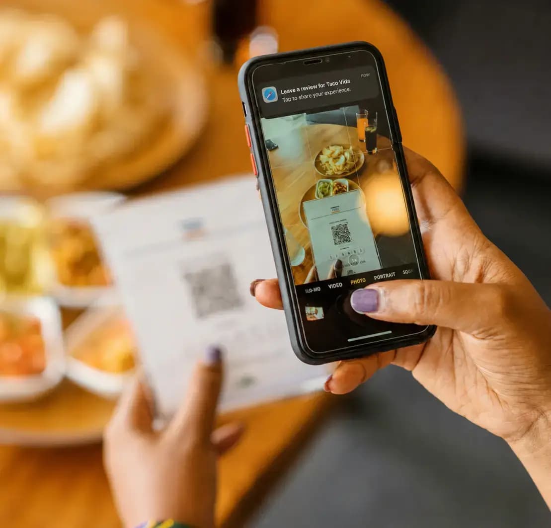 Guest scanning a Dishcus QR code at the table to leave feedback