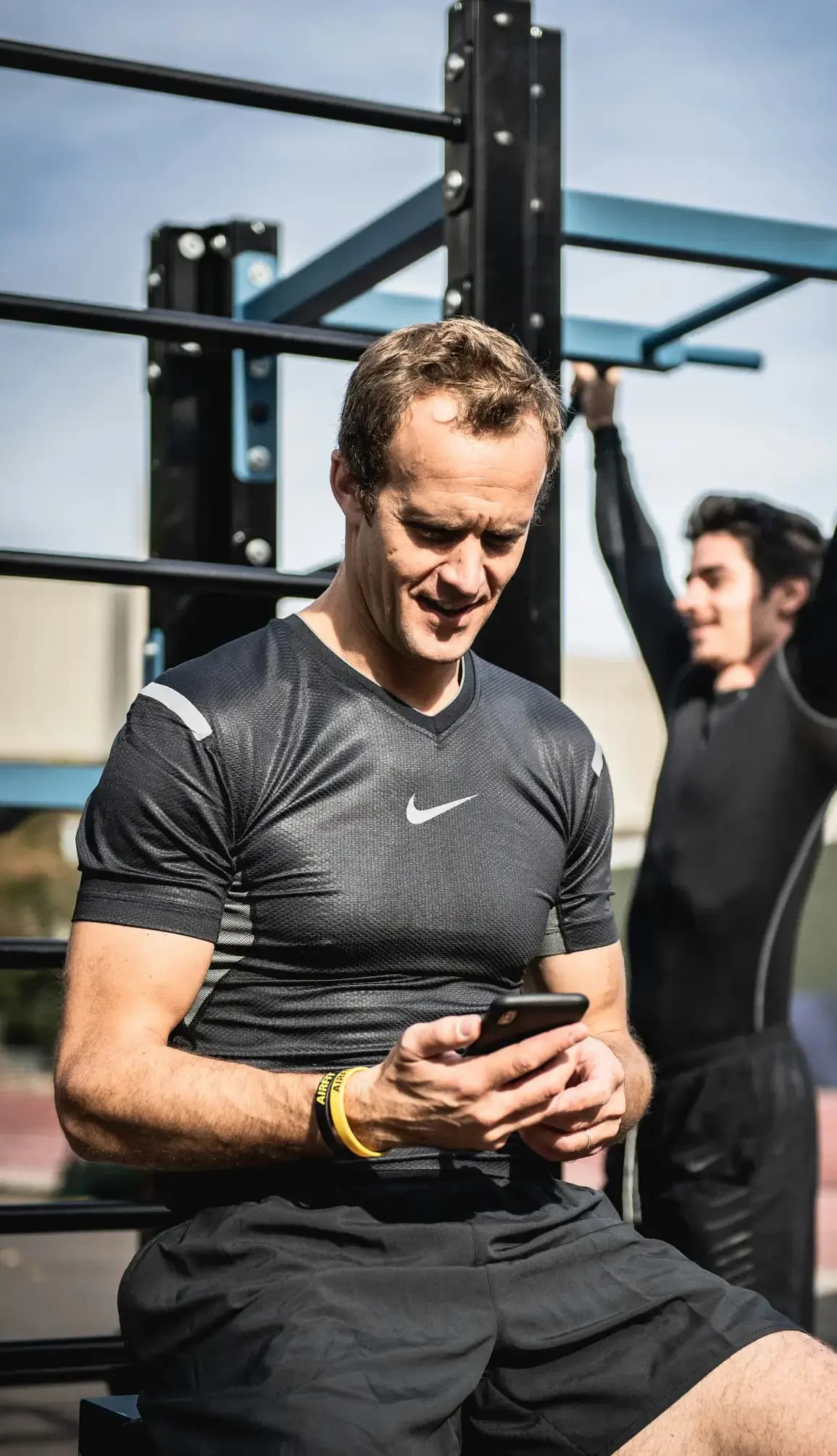 Personal trainer checking Google reviews on her phone at the studio