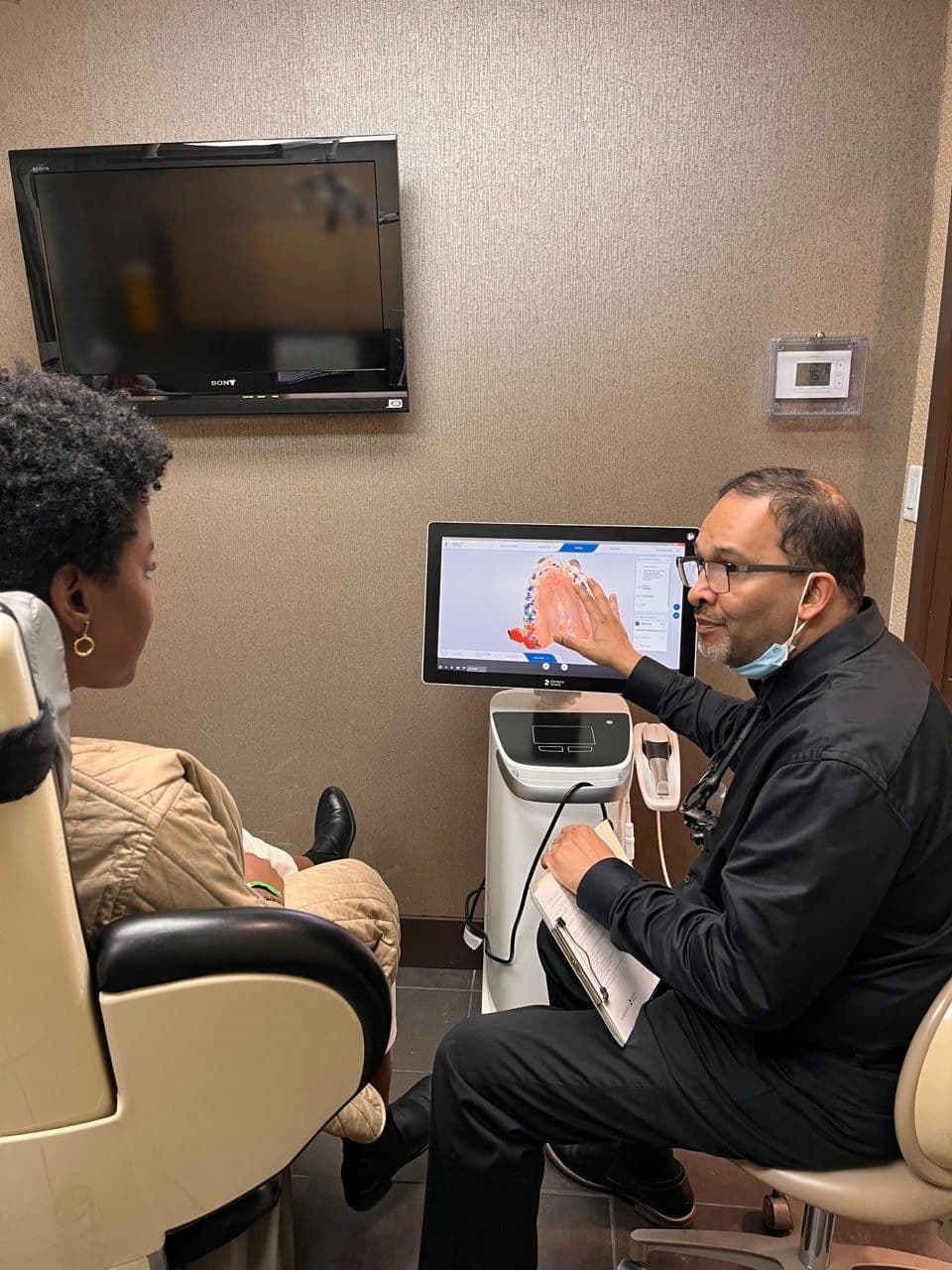 Midtown Dental Centre team reviewing patient feedback on a tablet at the front desk after hours