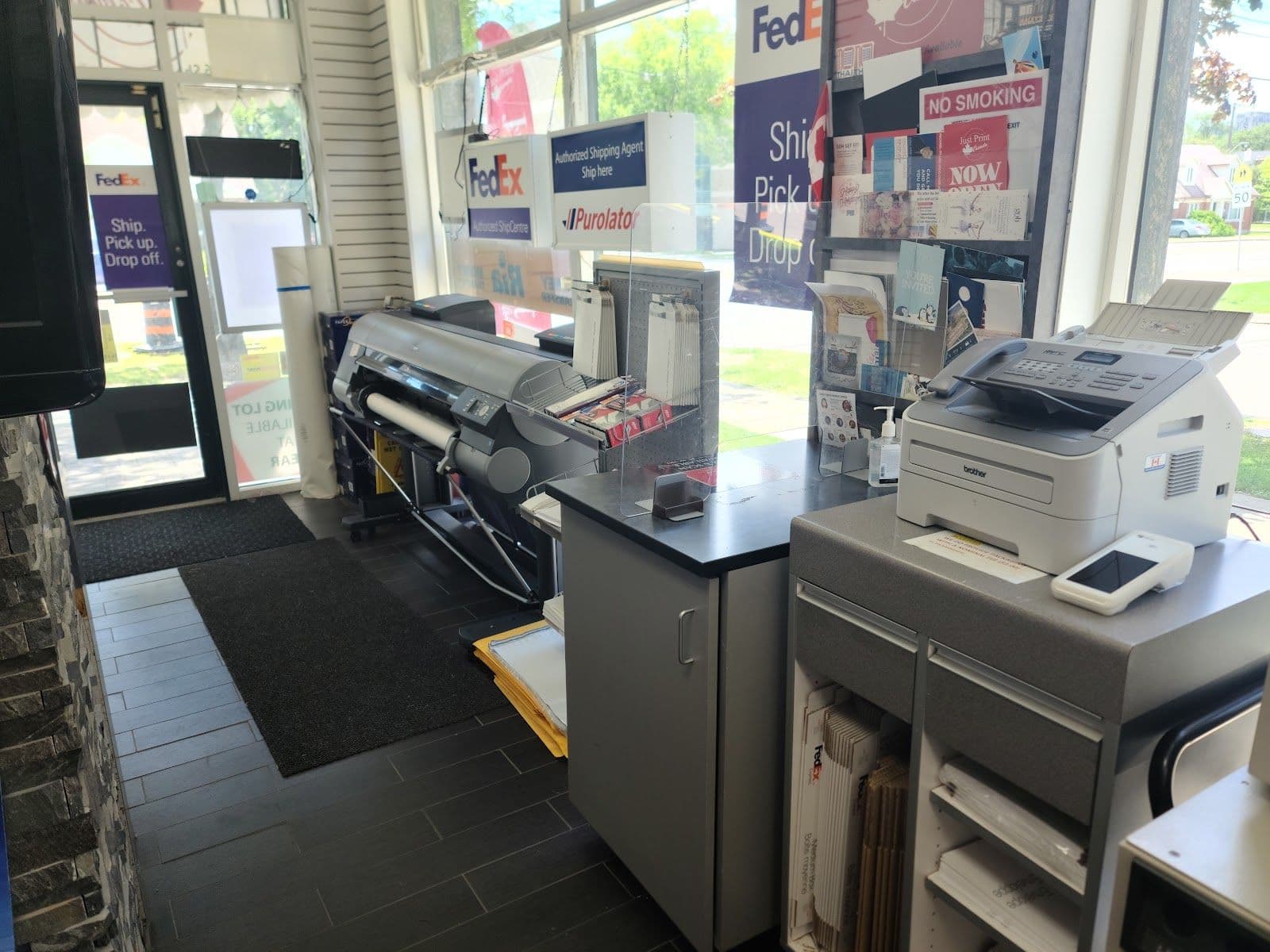 Just Print Canada Inc team reviewing guest feedback on a tablet at the front counter
