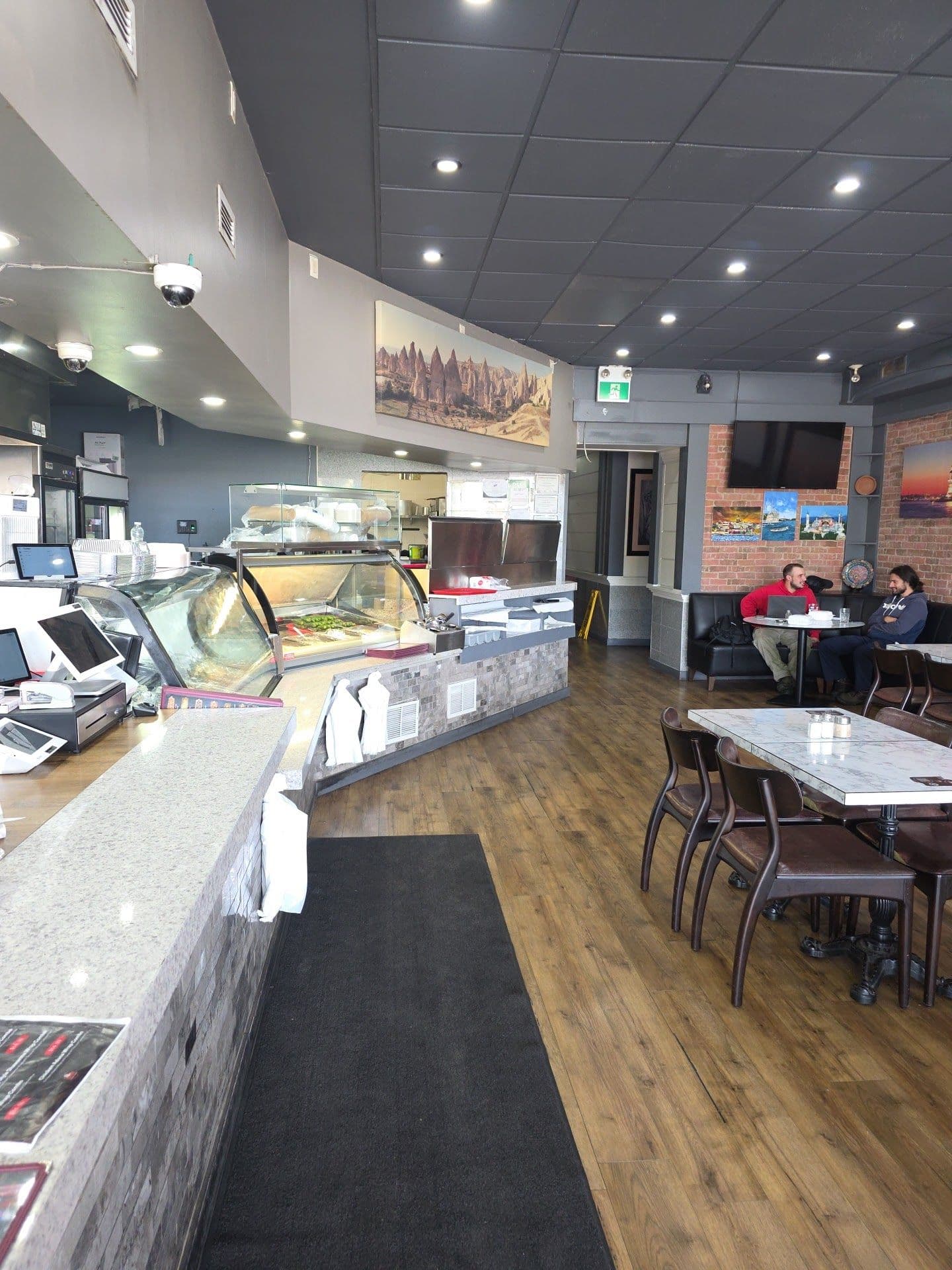Hatay Kebab House & Shawarma owner and team reviewing guest feedback and Google reviews on a tablet at the restaurant