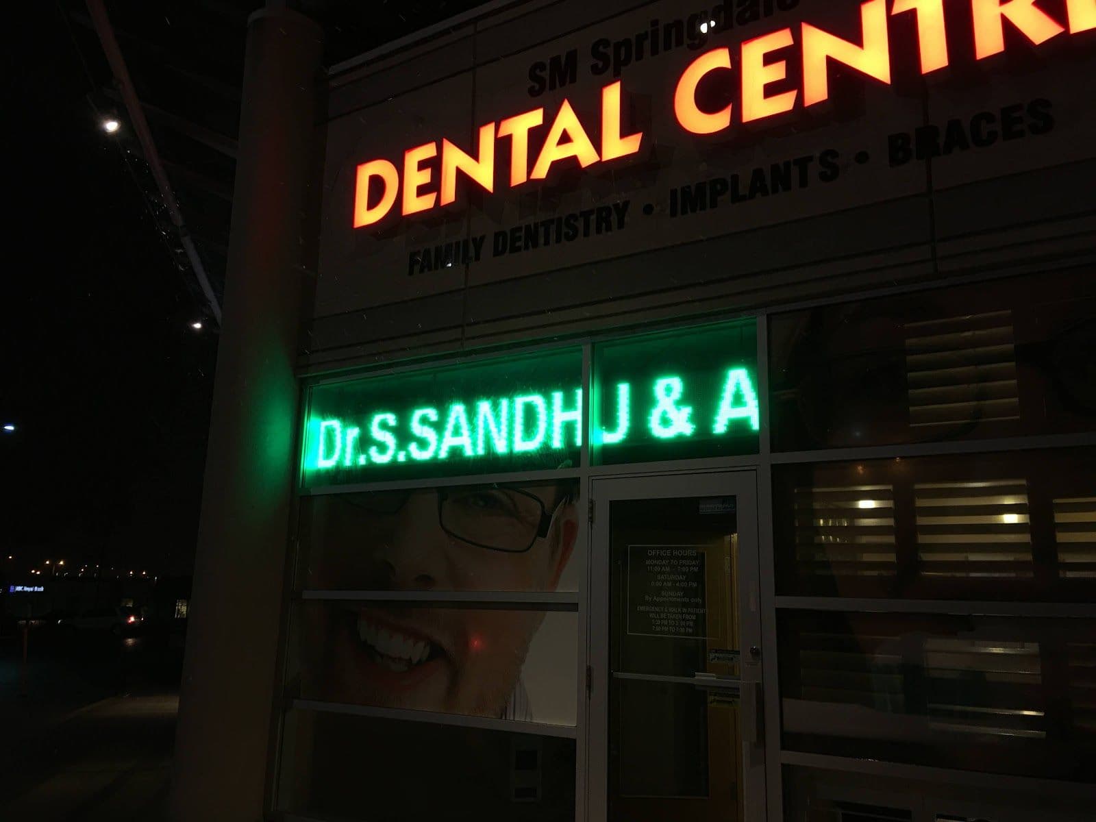 Sandhu Dentistry dental team gathered around a tablet reviewing patient feedback and Google ratings in one dashboard