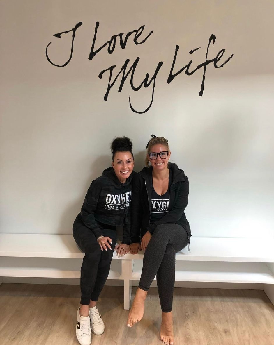 Personal trainer checking Google reviews on her phone at the studio