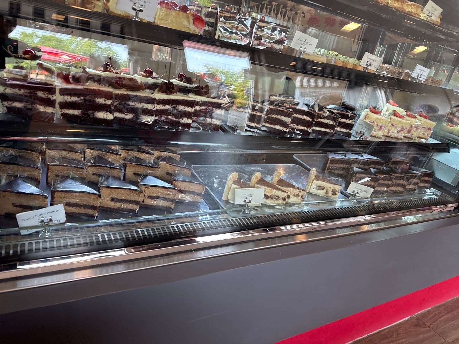Red Ganache owner and team gathered around a tablet reviewing Google guest feedback and recent cake order reviews at their Niagara Falls bakery