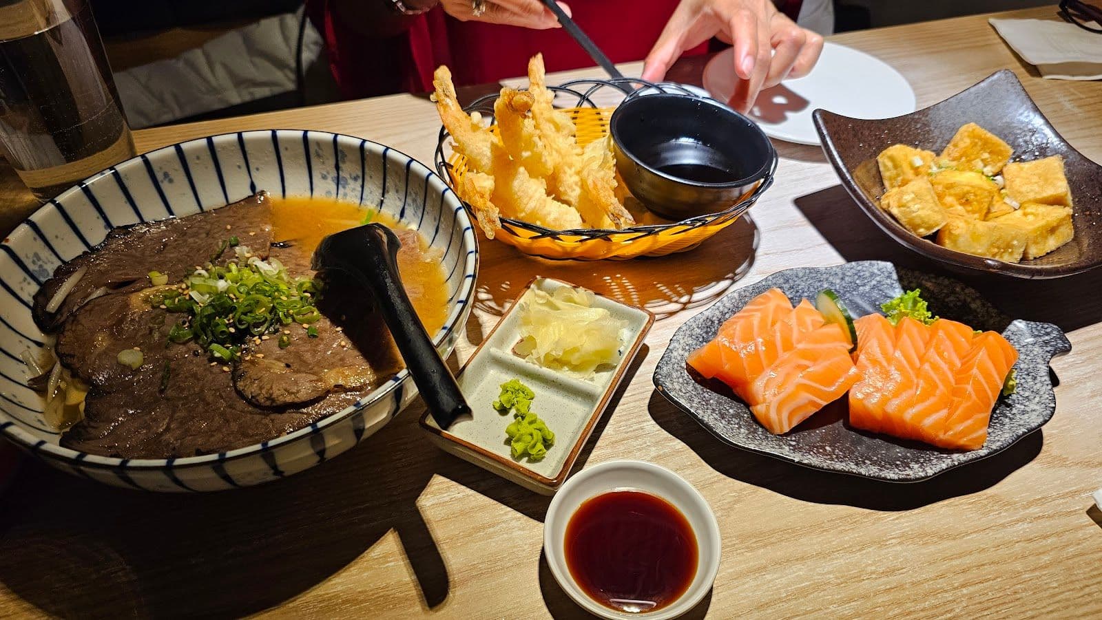 Restaurant team at Taku Sushi & Ramen reviewing guest feedback together on a tablet near the dining area