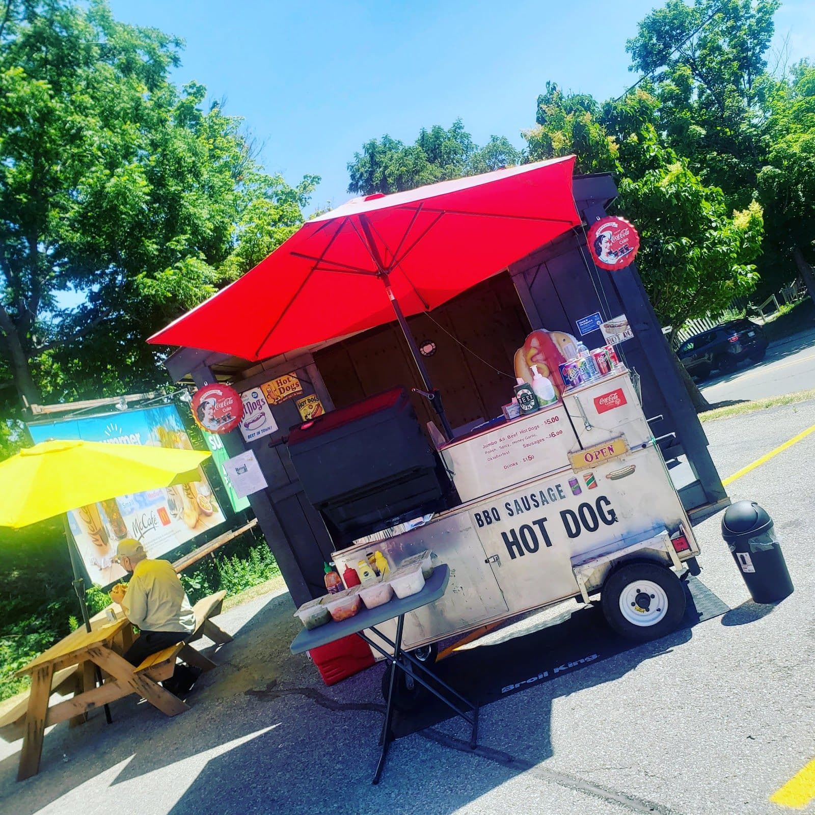 Owner of KW's Best Sausage Carts reviewing Google guest feedback and review themes on a tablet at the cart