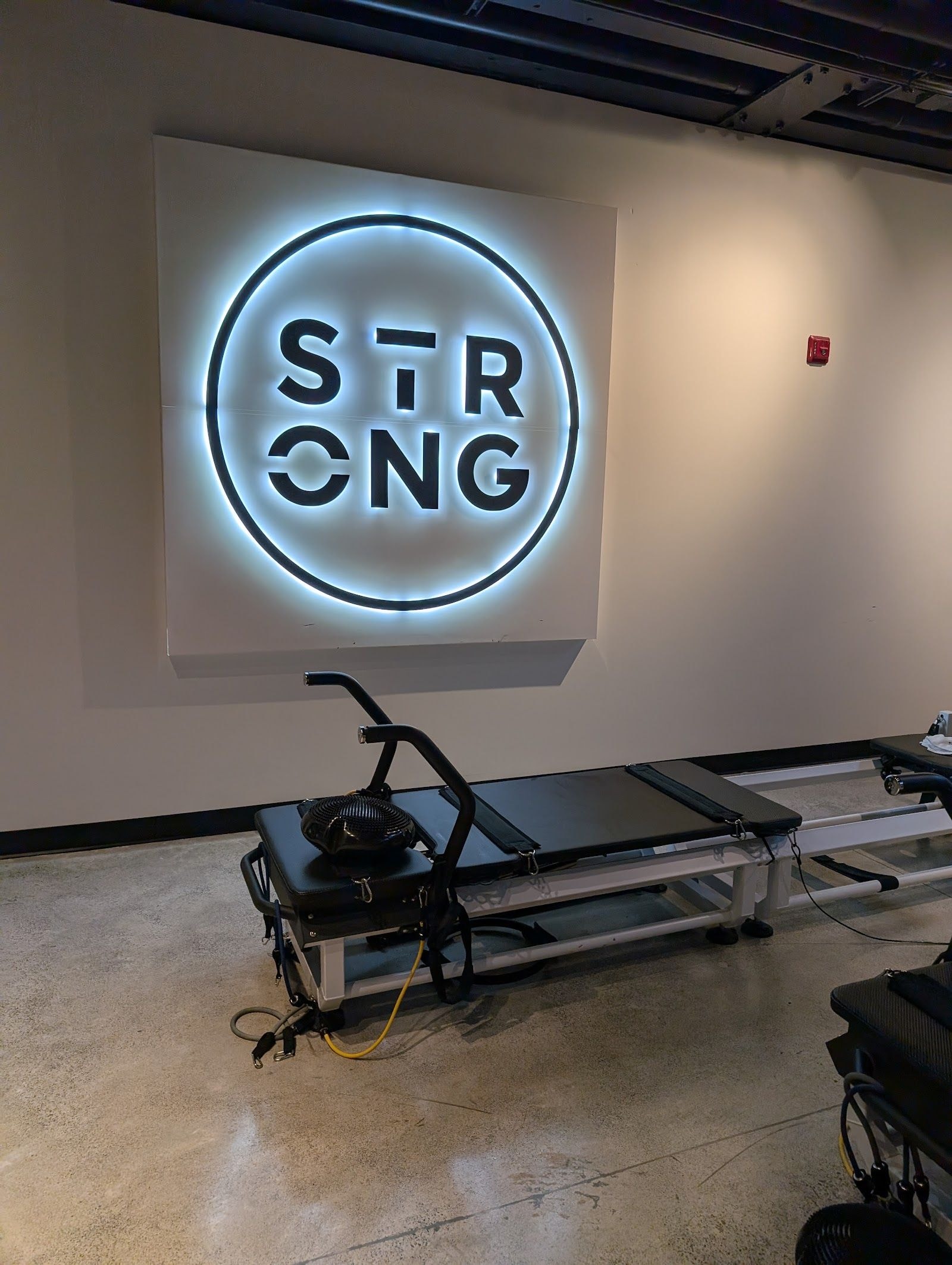 Personal trainer checking Google reviews on her phone at the studio