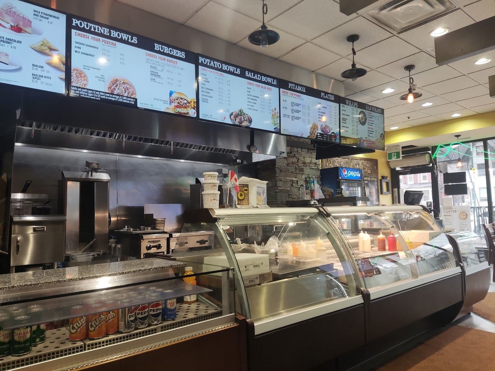 Pita Land - Spadina team reviewing guest feedback at the counter after a busy service
