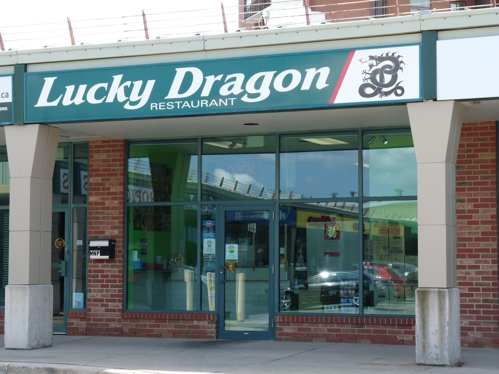 Restaurant team at Lucky Dragon Niagara Falls takeout reviewing guest feedback and Google reviews on a tablet at the counter