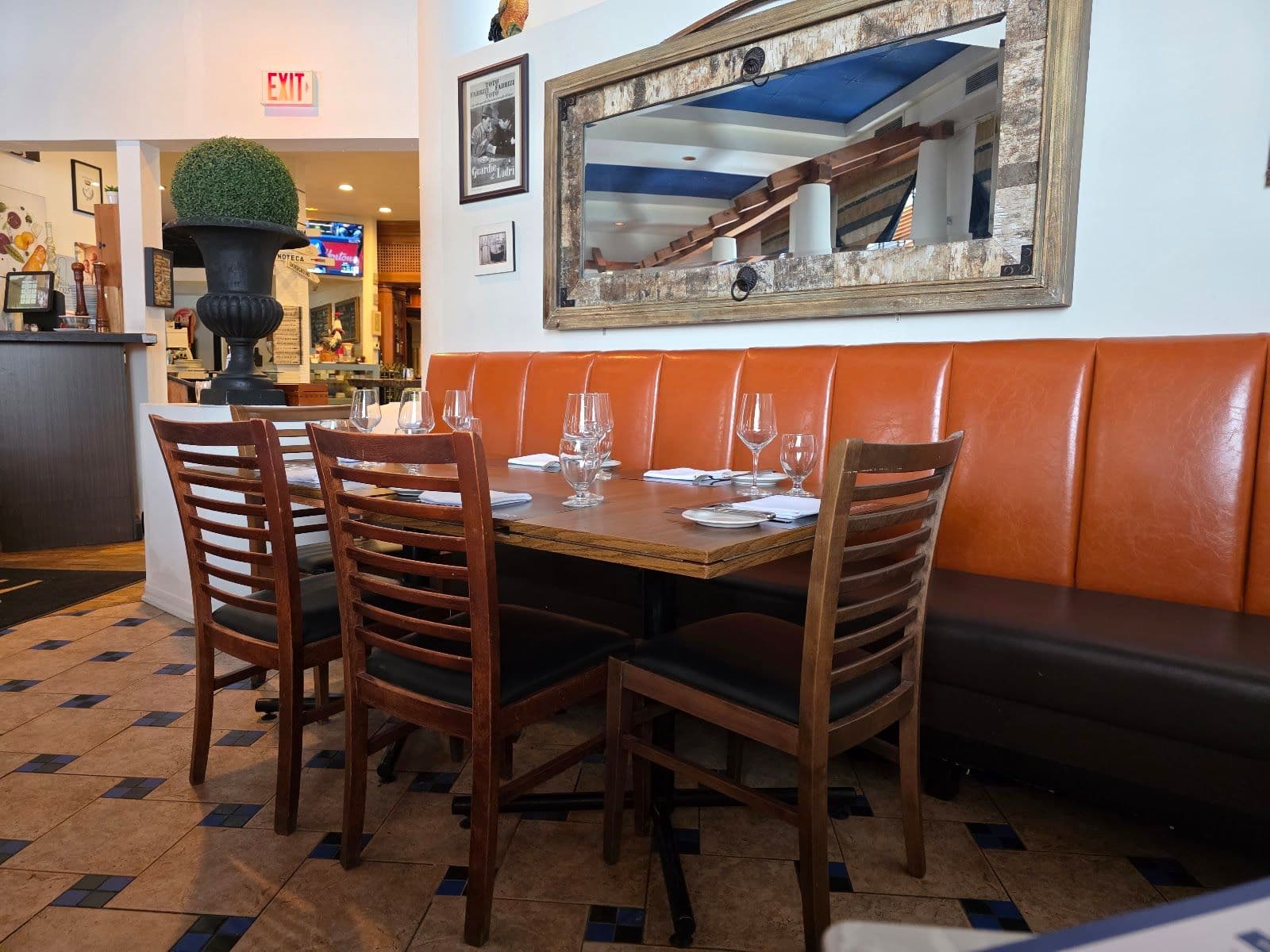Casa Mia Ristorante team gathered around a tablet reviewing guest feedback and Google review themes together at the restaurant