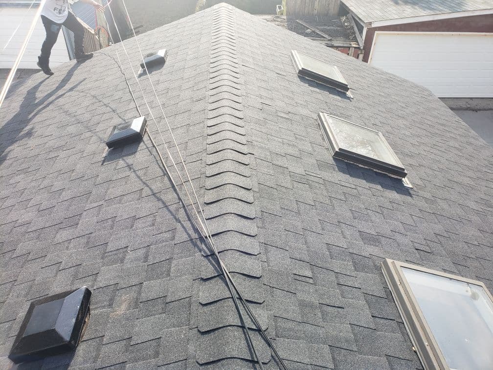 Quality Roofing Services LTD owner reviewing customer roofing feedback and Google reviews on a dashboard after a completed job