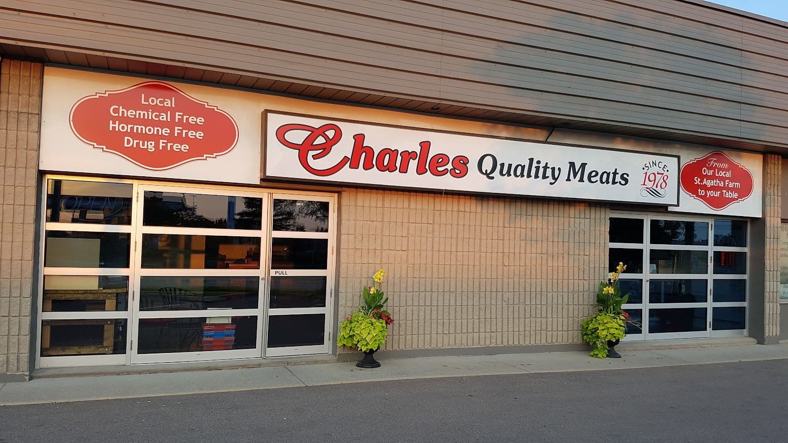 Owner and team at Charles Quality Meats reviewing Google guest feedback on a tablet behind the butcher counter