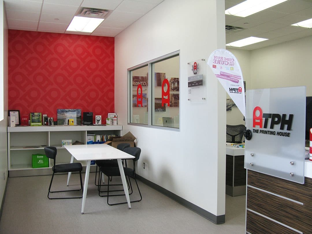 TPH The Printing House team reviewing customer feedback and Google reviews on a dashboard at their print shop counter