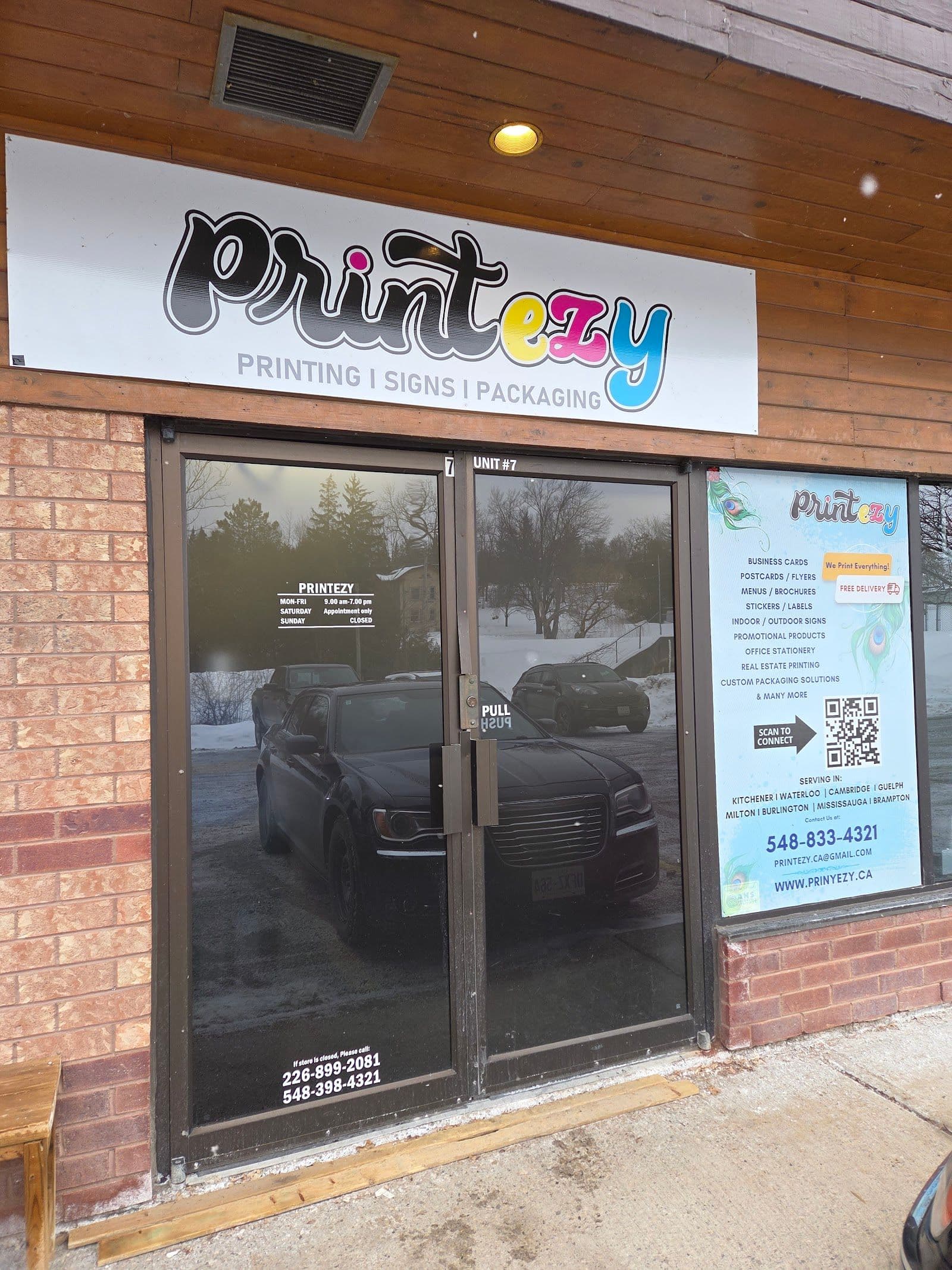 Printezy Kitchener team reviewing customer print feedback and Google reviews together at their shop