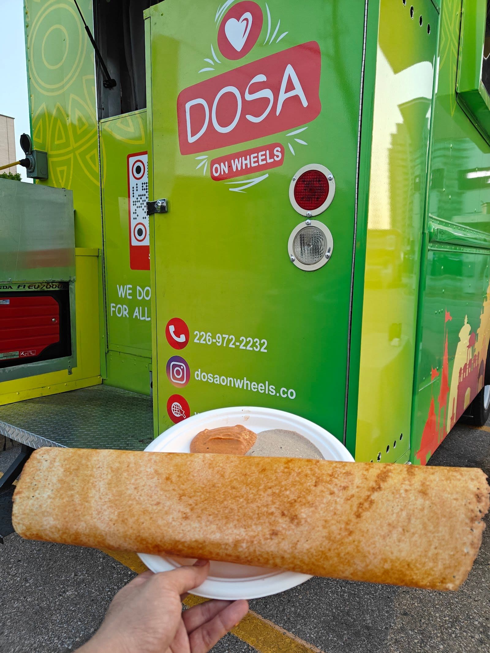 Dosa On Wheels team gathered around a tablet reviewing guest feedback and Google reviews together at the restaurant counter
