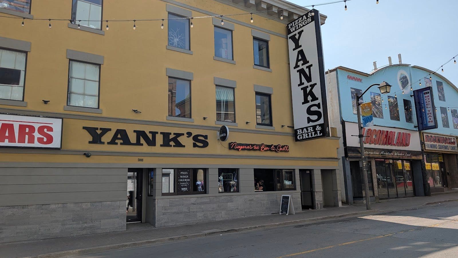 Restaurant manager and team at Yank's Old Niagara Bar & Grill reviewing guest feedback together on a tablet