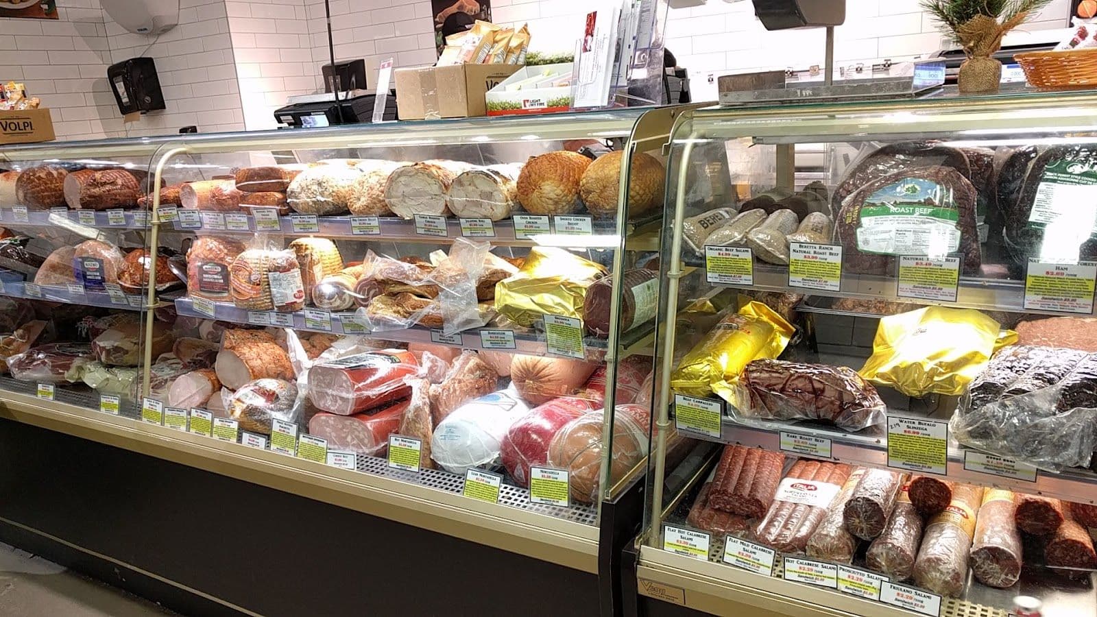 A manager and team member at Vincenzo's reviewing guest feedback together at a counter surrounded by gourmet products