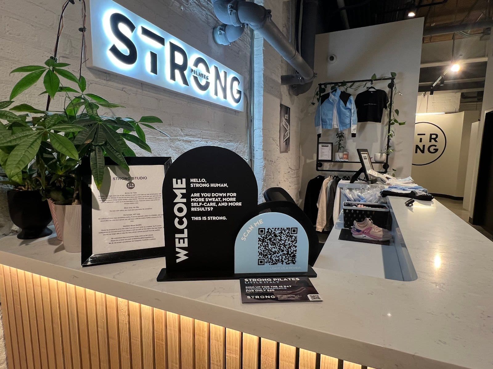 Strong Pilates Little Italy Toronto owner and staff reviewing member feedback together at the studio front desk
