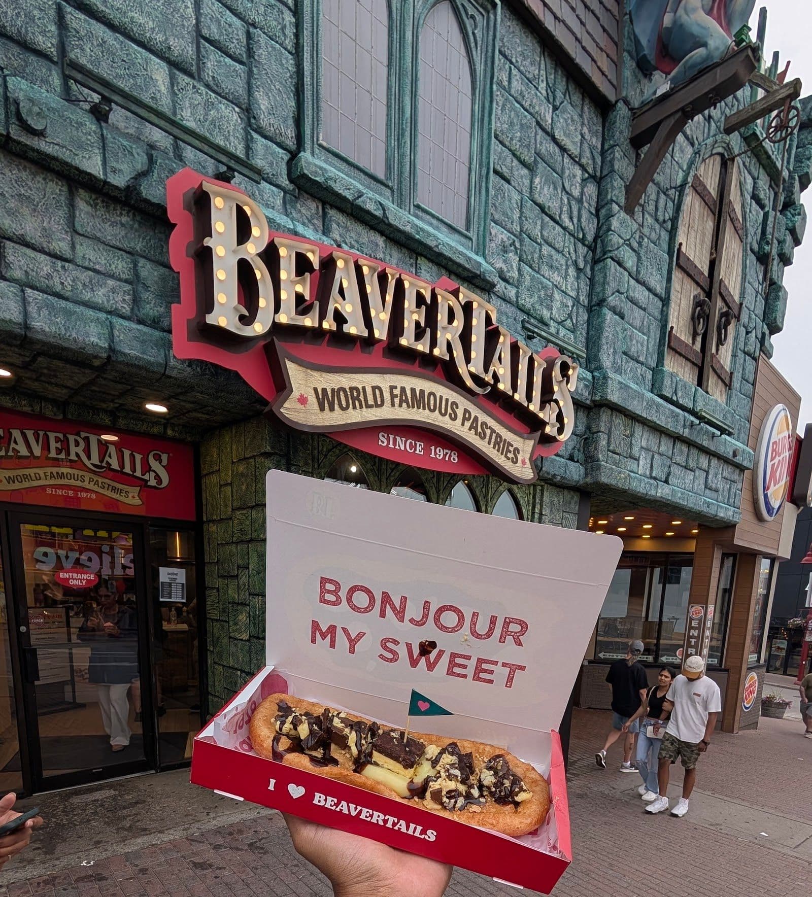 BeaverTails Niagara Falls team reviewing guest feedback together at their stand near the Falls