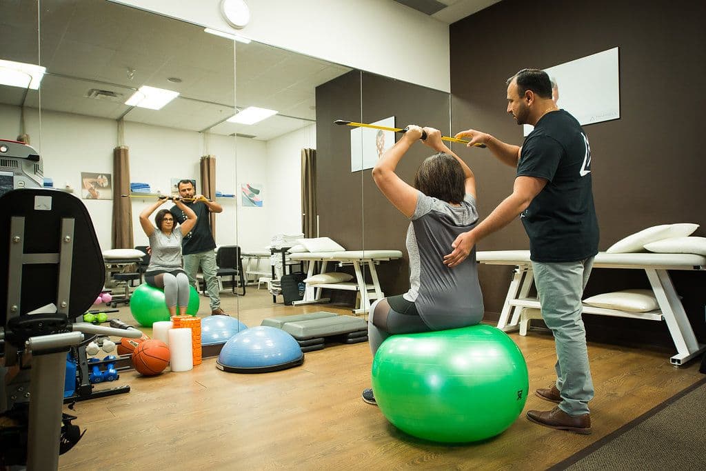 Triangle Physiotherapy Mississauga clinic team reviewing patient feedback and Google ratings together at the front desk