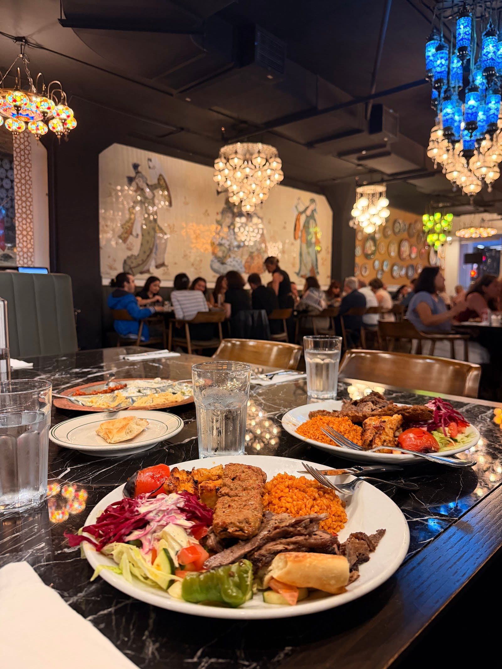 Istanbul Kebab House owner and team reviewing guest feedback and Google reviews together on a tablet at the restaurant