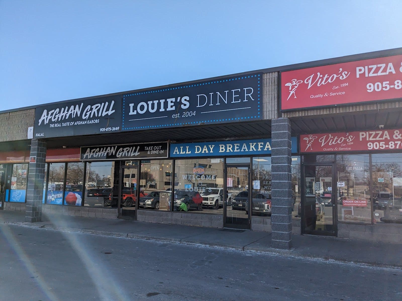 Louie's Diner owner reviewing guest feedback and Google reviews on a tablet at the front counter