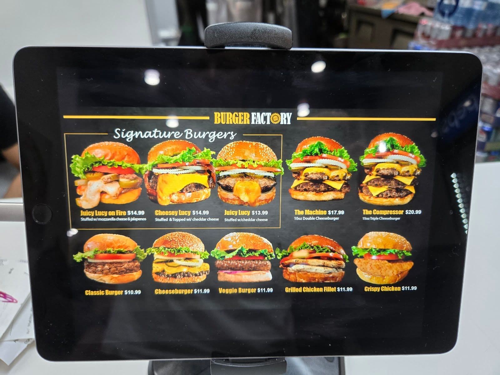 Burger Factory team gathered around a tablet reviewing guest feedback and Google review themes in their restaurant