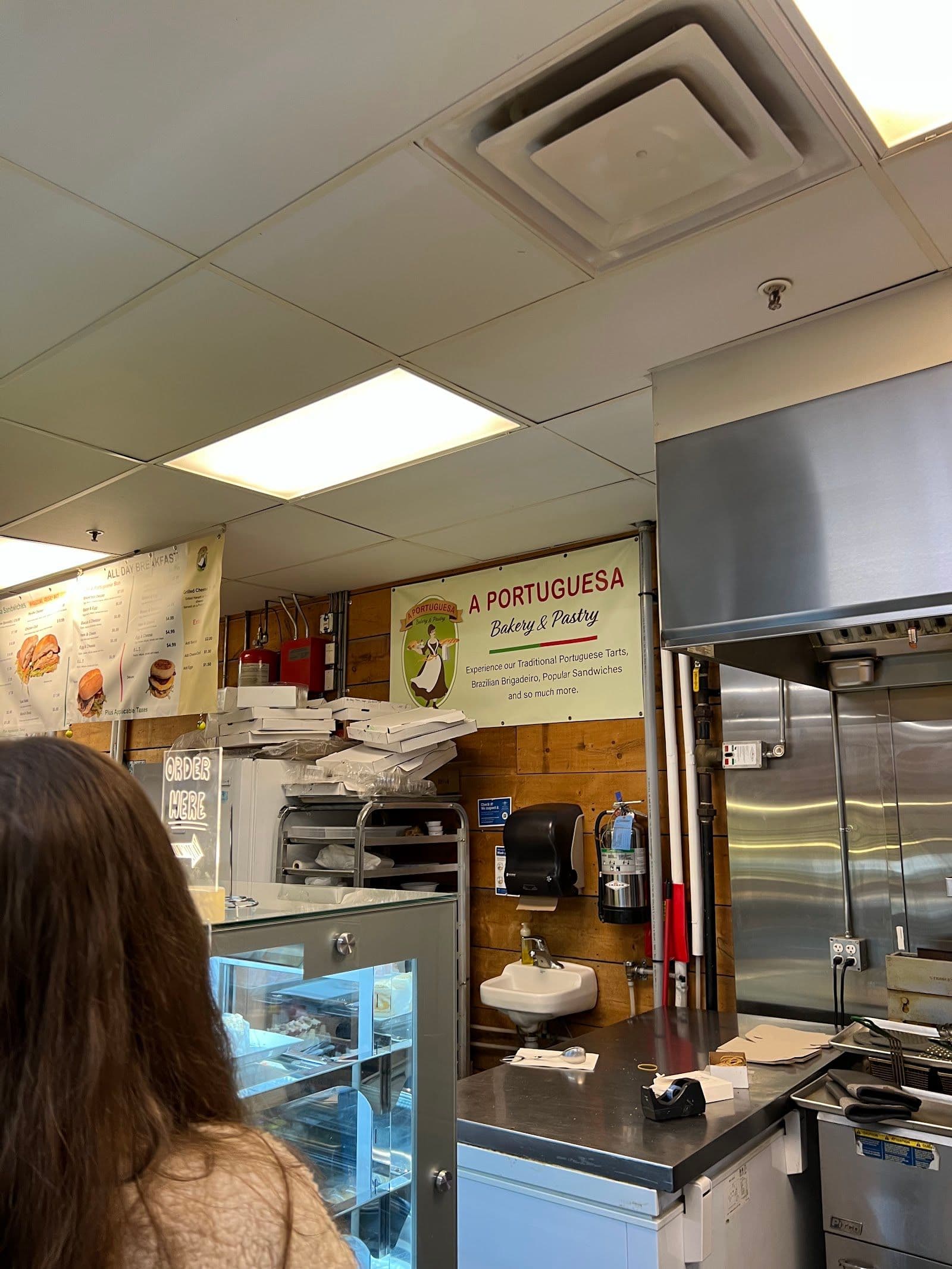 Owner and team at A Portuguesa Bakery reviewing Google guest feedback on a tablet at their market booth
