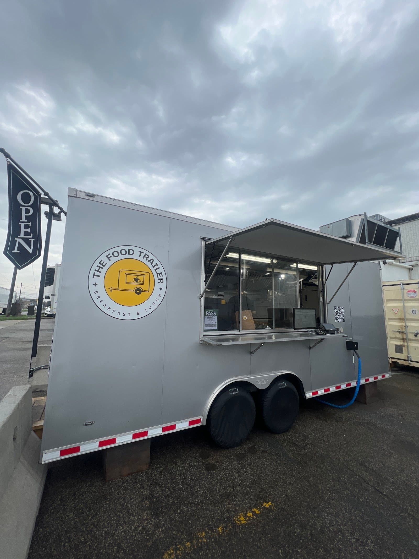 TheFoodTrailer owner reviewing guest feedback and Google reviews on a dashboard at the food trailer counter
