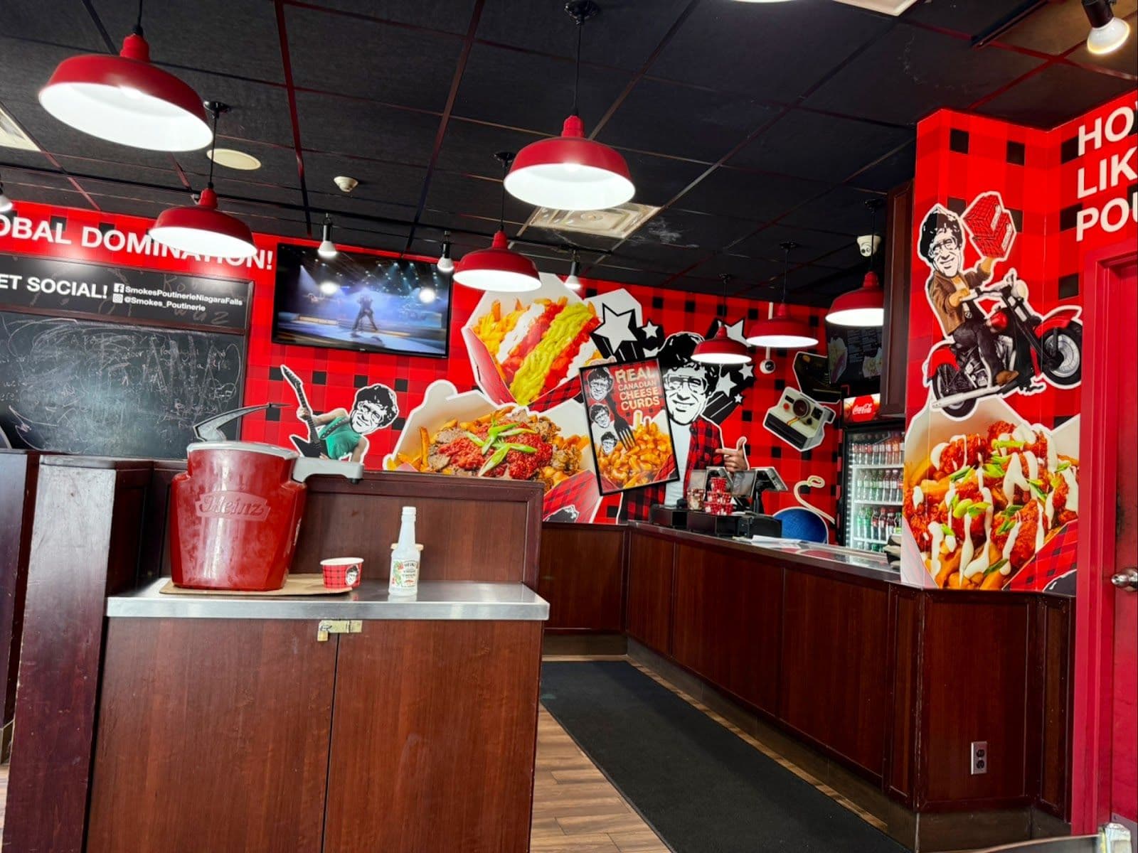 Smoke's Poutinerie owner and team reviewing guest feedback and Google reviews together at the counter